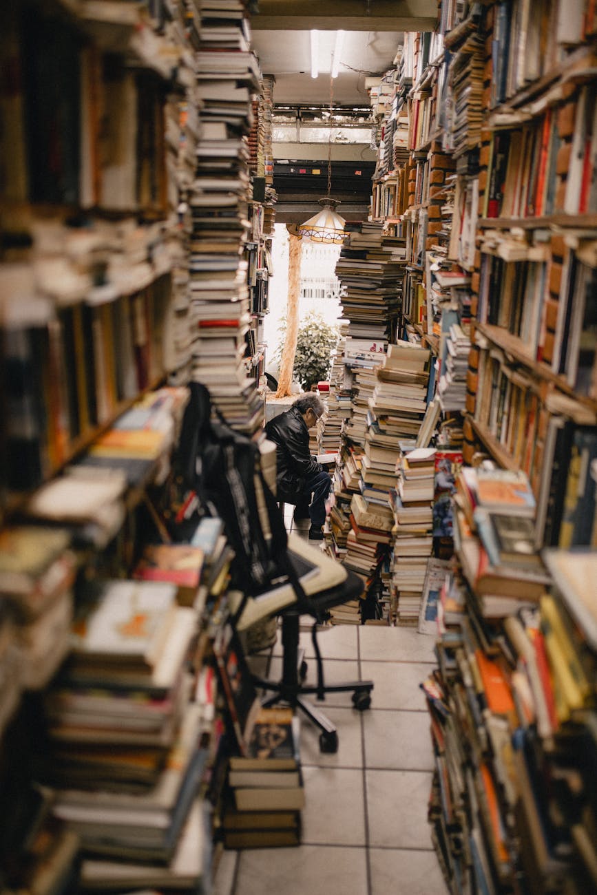 man sitting in floor of room full of books